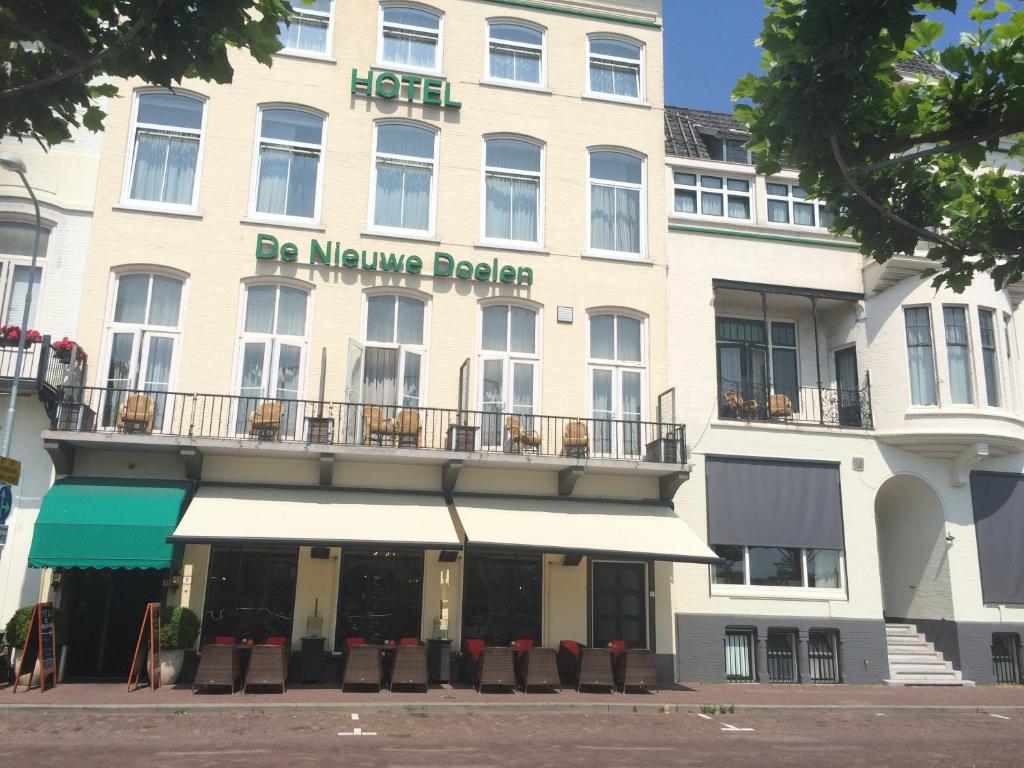 a building with a large building behind it at Hotel en privé-wellness De Nieuwe Doelen in Middelburg