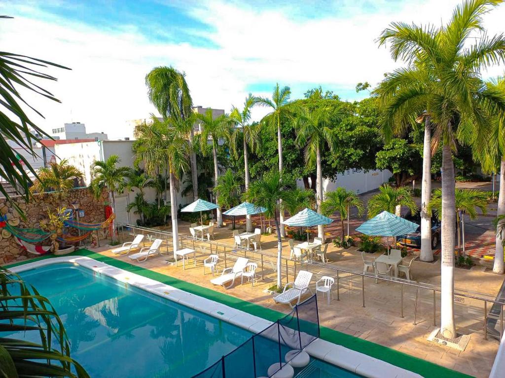 uma piscina exterior com cadeiras e guarda-sóis em Vajamar Hotel em Valledupar