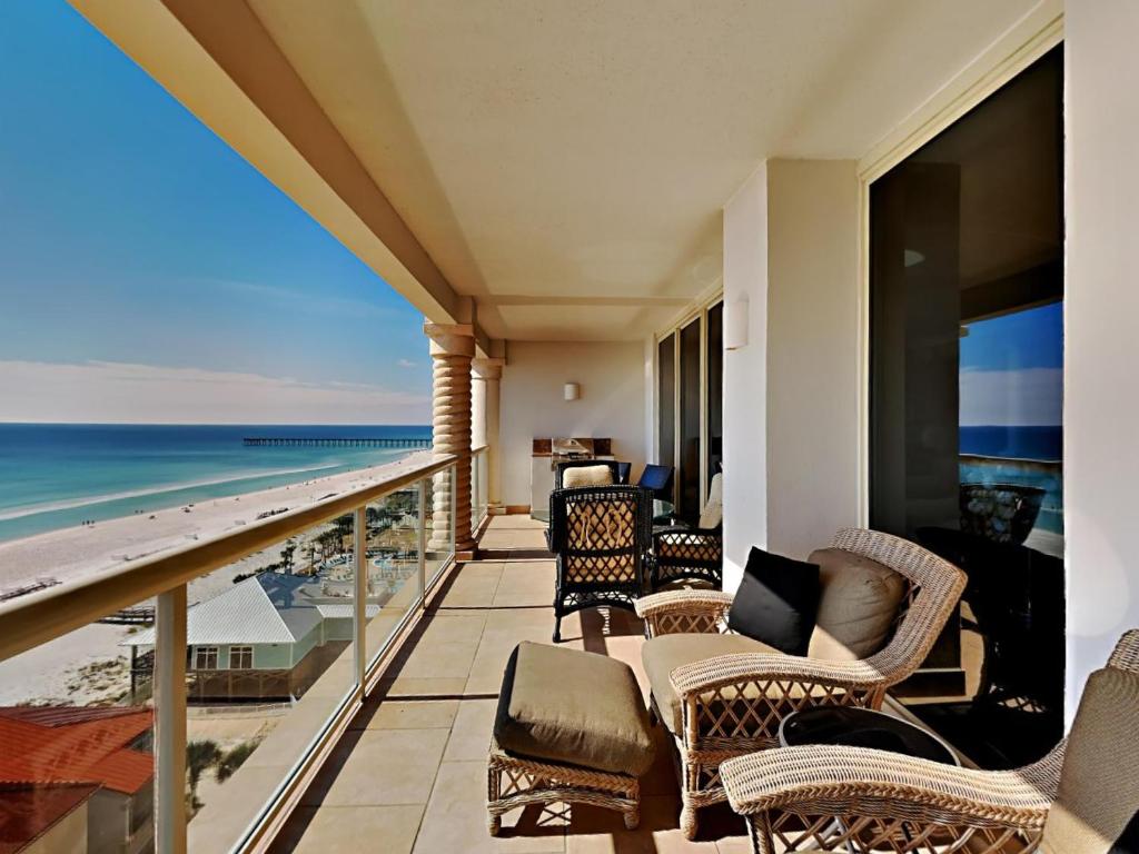 a balcony with chairs and a view of the ocean at Beach Club 904c in Pensacola Beach