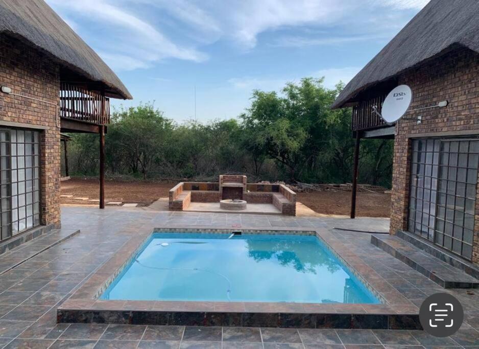 a swimming pool in a yard with a building at Kruger Nest in Marloth Park