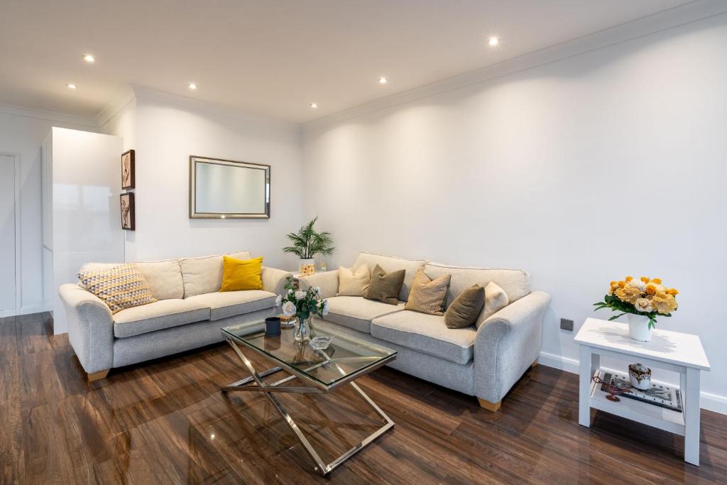 a living room with a couch and a table at Beachfront Penthouse , Roof Balcony With Sea View, Free Use of Hotel's Spa, Sauna, Gym and Pool in Brighton & Hove