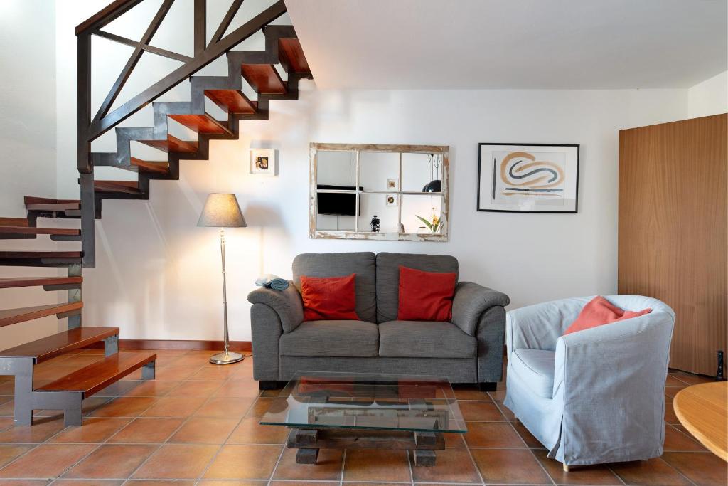 een woonkamer met een bank en een trap bij Finca Emblemática - Nº1 Tisalaya in La Vegueta