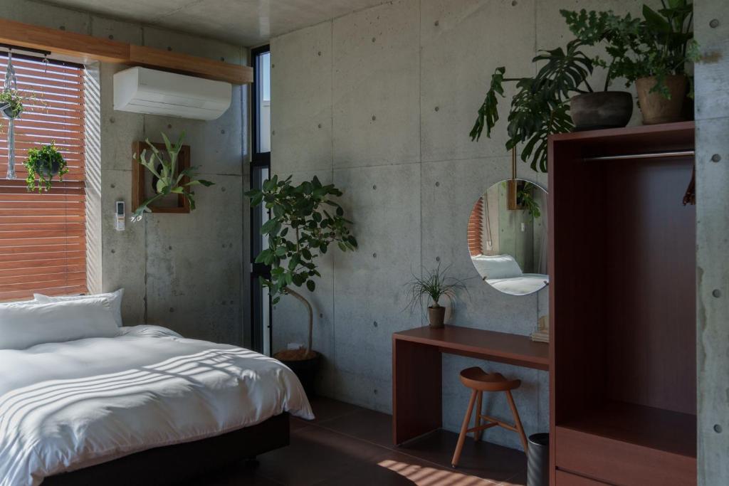 a bedroom with a bed and a desk with plants at G.bouquet in Nakijin