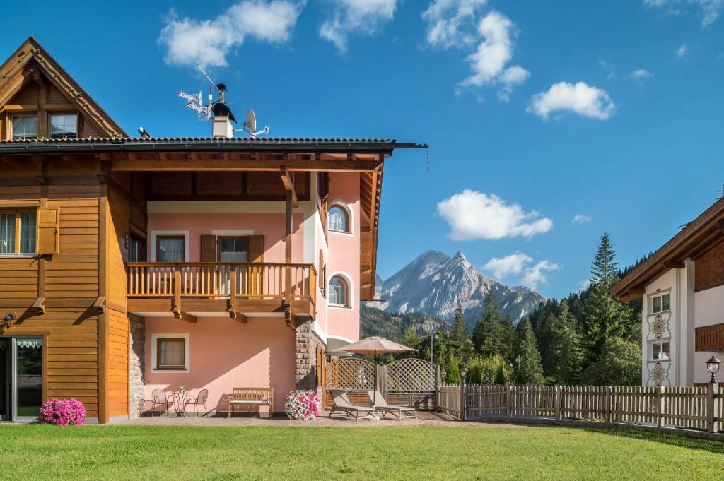 a house with a balcony and mountains in the background at Villa Lory 2 in Canazei