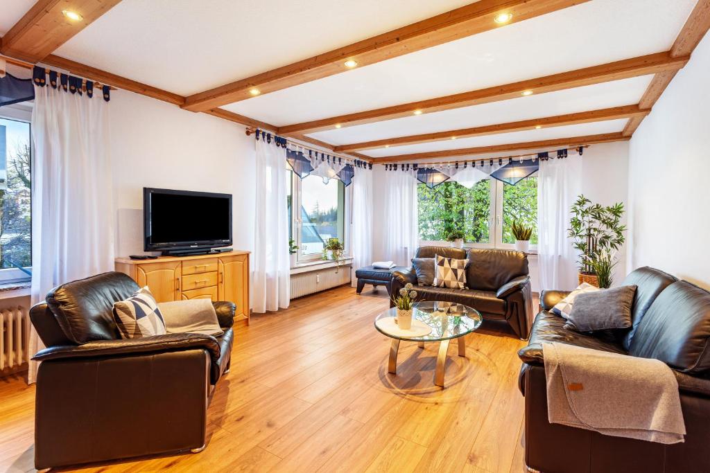 a living room with leather furniture and a flat screen tv at Ferienwohnung Busch in Meinerzhagen