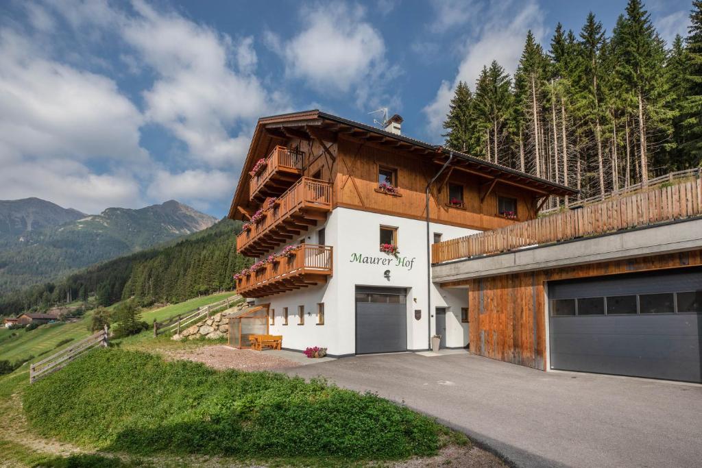 um edifício com uma garagem ao lado em Pfattenspitz Maurerhof em Valdurna