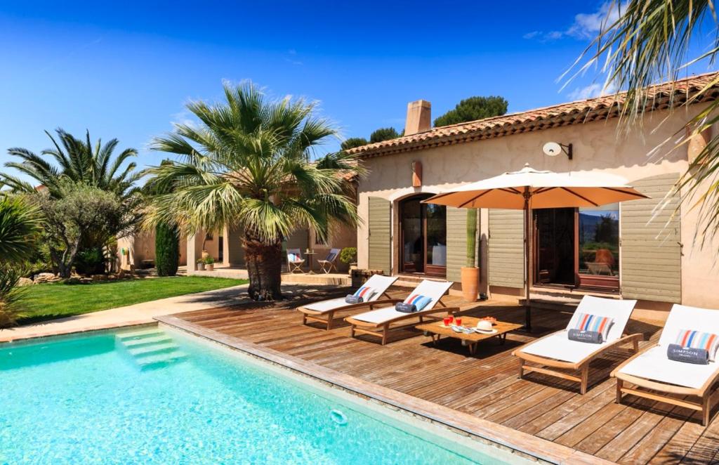 Cette villa dispose d'une piscine avec des chaises et un parasol. dans l'établissement Puntayucca, à Laouque