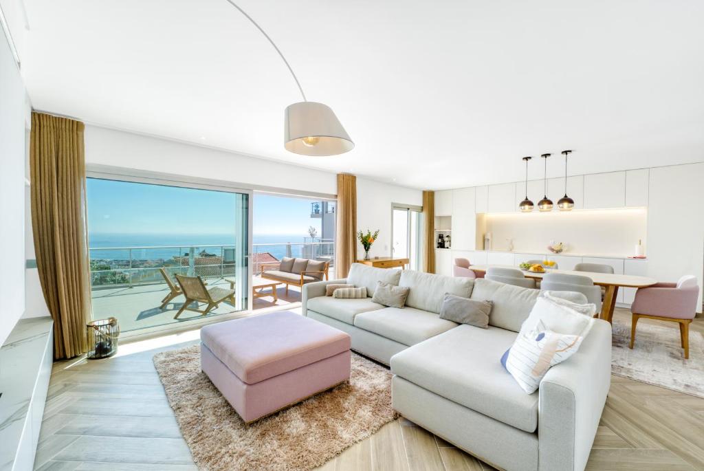 sala de estar con sofá blanco y taburete rosa en Panoramic Views - Terrace, Sea Views & Pool en Nazaré