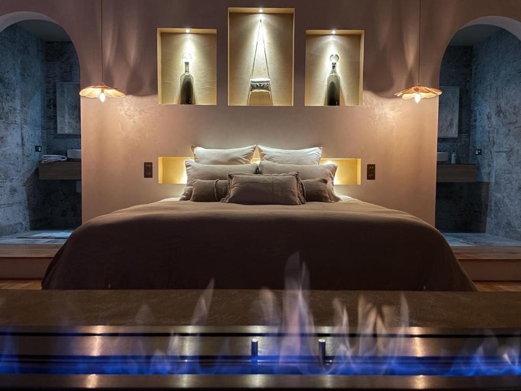 1 dormitorio con 1 cama grande con luces en la pared en Mas Escala Suites & Spa, en Istres
