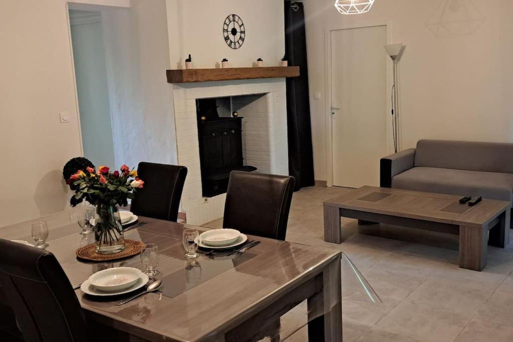 - un salon avec une table à manger et une cheminée dans l'établissement Logement entier chez Hélène, à Sainte-Gemme-Martaillac