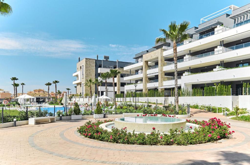 a large apartment building with a fountain in a courtyard at Apartament Flamenca Village Lime & Lemon in Orihuela Costa