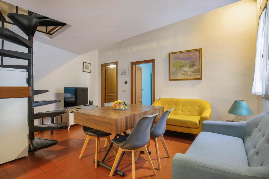 a living room with a table and chairs and a couch at L'Attico di Sant'Ambrogio in Florence