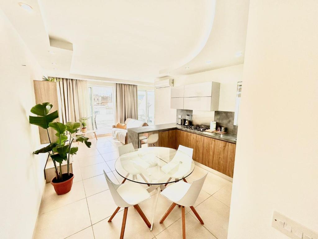 een keuken met een tafel en stoelen in een kamer bij The Papillon Penthouse in Santa Vennera