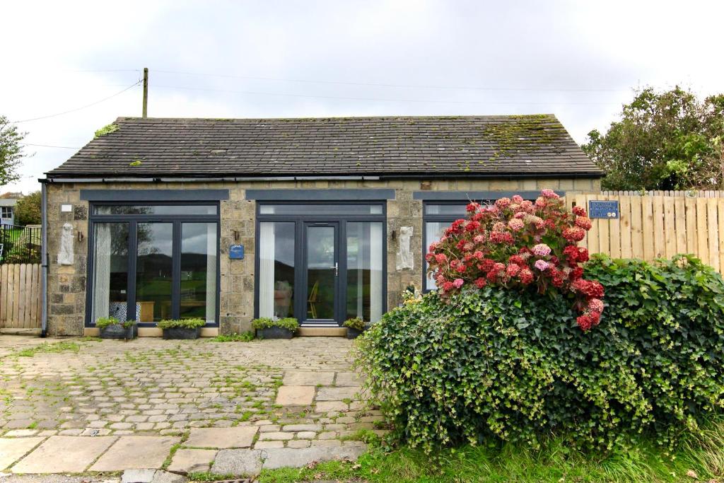 una pequeña casa con un montón de ventanas en Farways Den, en Haworth