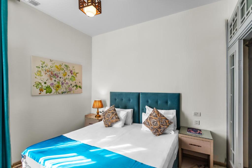 um quarto com uma cama com uma cabeceira azul em Best Center Boutique Hotel em Baku