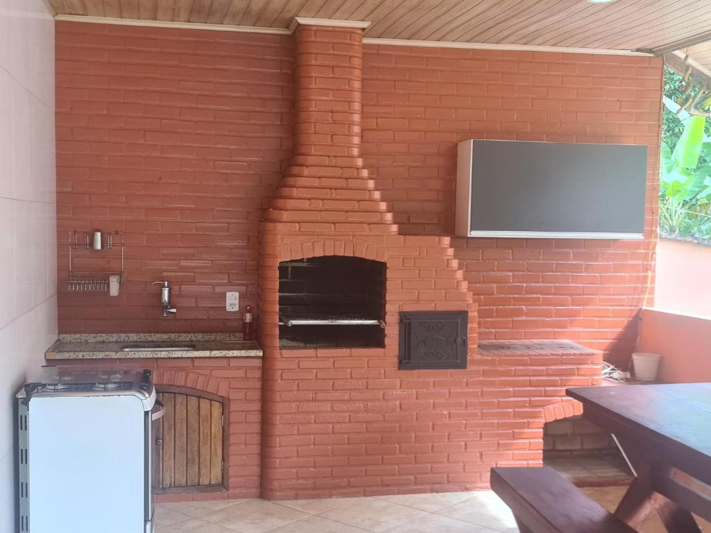 un forno in mattoni con una TV su un muro di mattoni di Recanto do Valdir ad Angra dos Reis