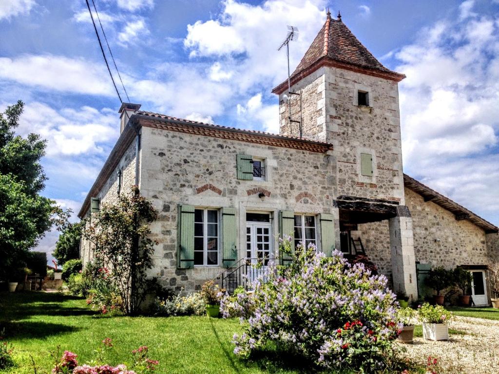 un antiguo edificio de piedra con una torre encima en Gîte en Lot-et-Garonne avec piscine et jardin de 6000m2, en Bourran