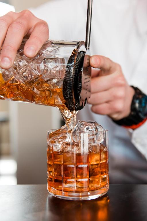 a person is pouring a drink into a glass at Hotel A&#39;mare in Zadar