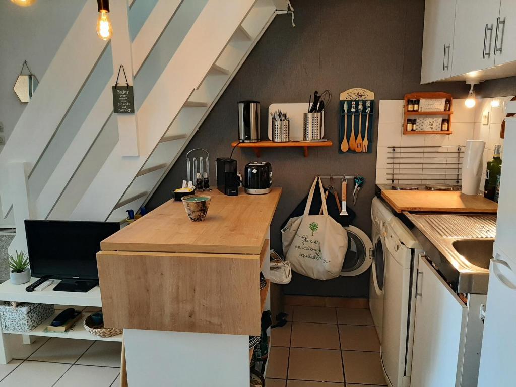 une cuisine avec un comptoir en bois dans une pièce dans l'établissement Charmante Villa Patio avec Terrasse : Proche Plages et Centre, Idéale pour 4 Personnes - FR-1-239-789, à Capbreton