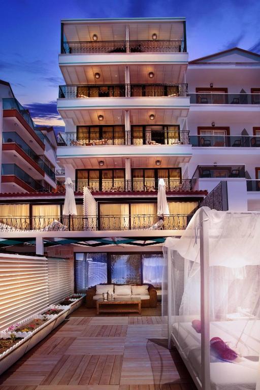 ein Mehrfamilienhaus mit Balkon und Bett in der Unterkunft Nur Beach Hotel in Kaş