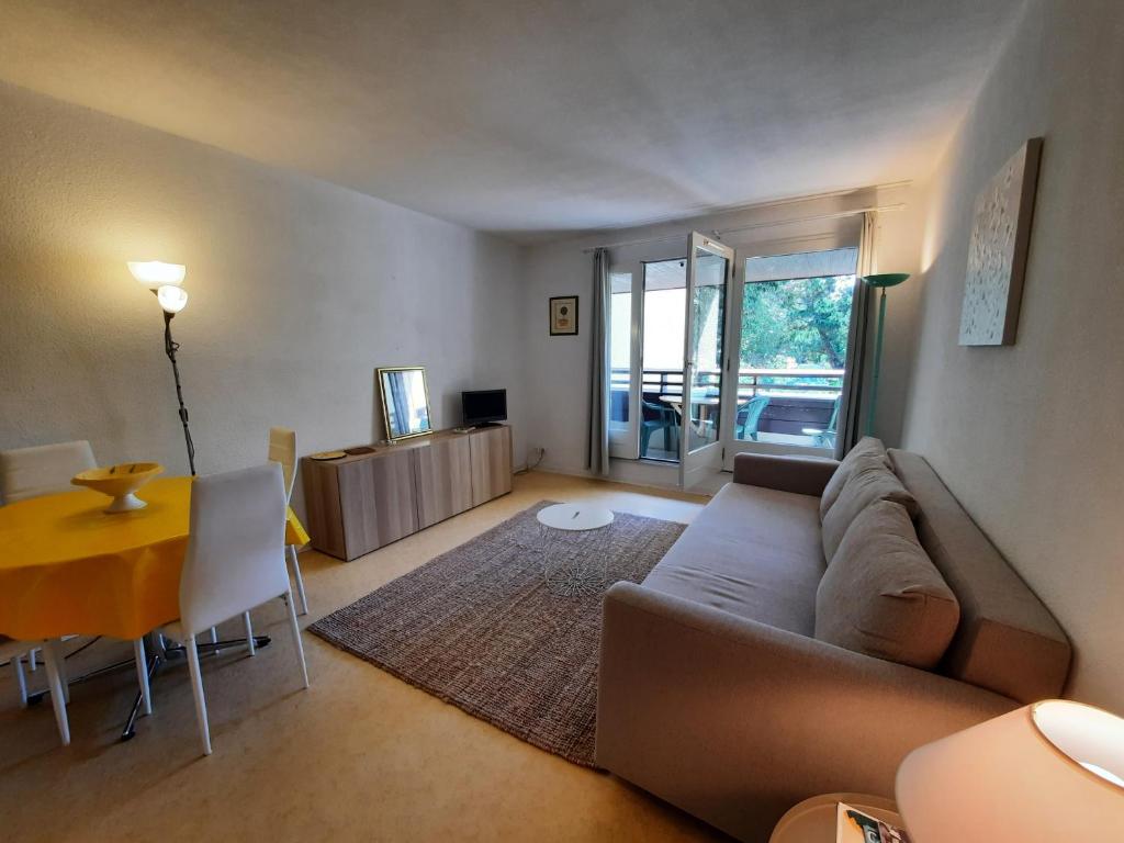 salon z kanapą i stołem w obiekcie Appartement Lumineux à Seignosse, Proche Plage, Commerces et Activités, Parking, Wifi et Balcon - FR-1-239-813 w mieście Seignosse