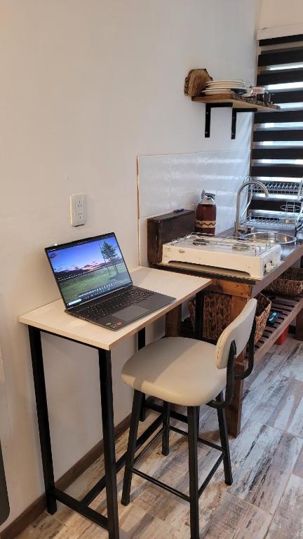 un ordenador portátil sentado en un escritorio con una silla en Tiny House Ushuaia en Ushuaia