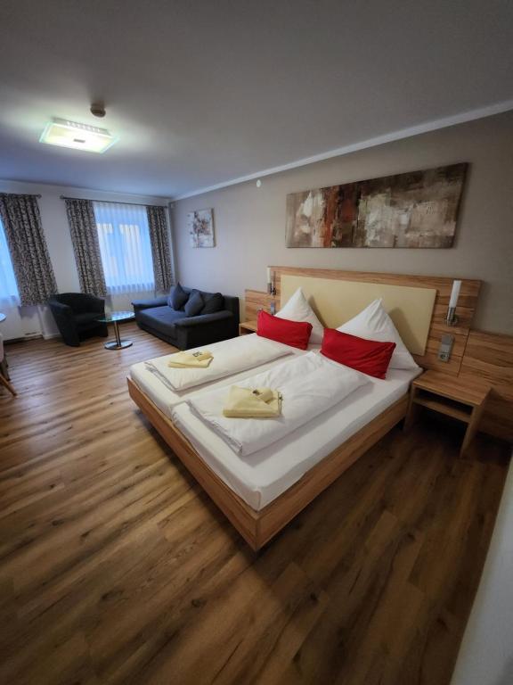 a bedroom with a large bed with red pillows at Posthotel Traube in Donauwörth