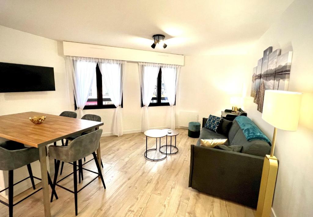 ein Wohnzimmer mit einem Tisch und einem Sofa in der Unterkunft T2 Hyper centre 3 étoiles Rue du Casino in Aix-les-Bains