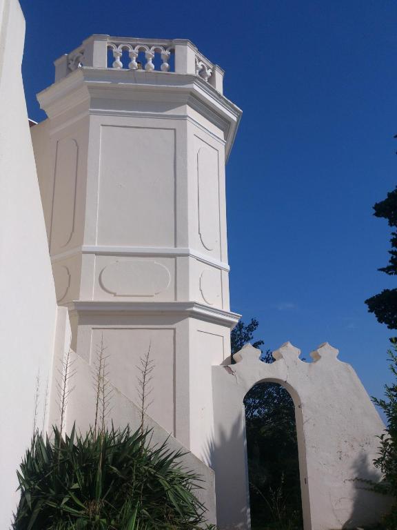 une tour d'horloge blanche dans un bâtiment blanc dans l'établissement Villa Les Terrasses Tamaris Les Sablettes, à La Seyne-sur-Mer