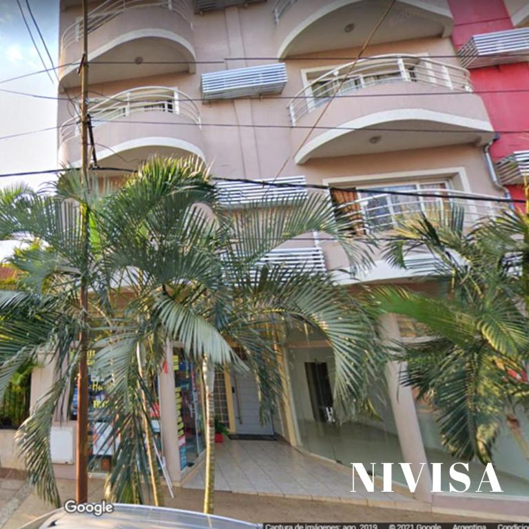 a building with palm trees in front of it at Edificio NIVISA in Posadas