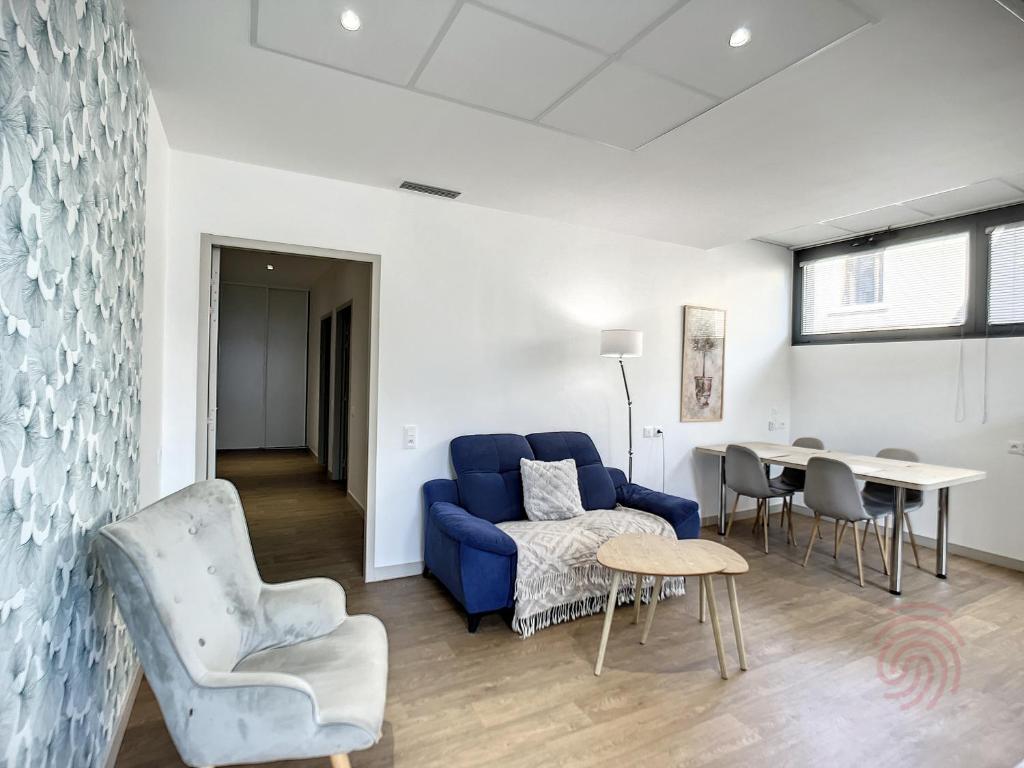 uma sala de estar com um sofá azul e uma mesa em Appartement Lamalou-les-Bains, 3 pièces, 4 personnes - FR-1-451-170 em Lamalou-les-Bains