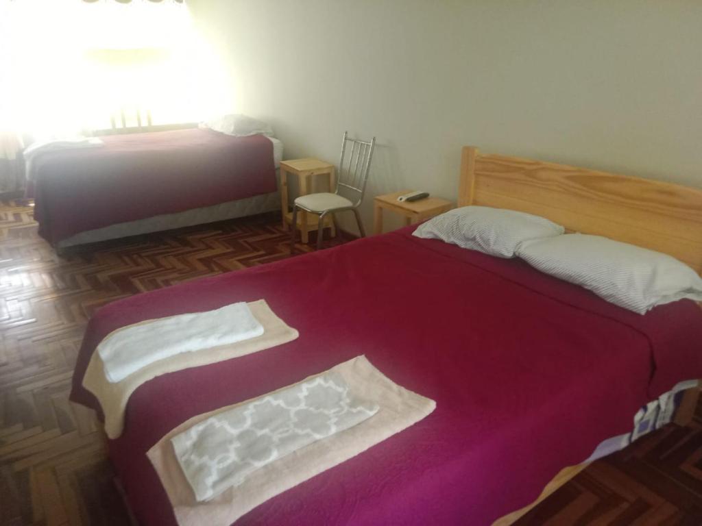 1 dormitorio con 1 cama grande con manta morada en Nuevo Chez Julie 2, LA casa de Julie, en Arequipa