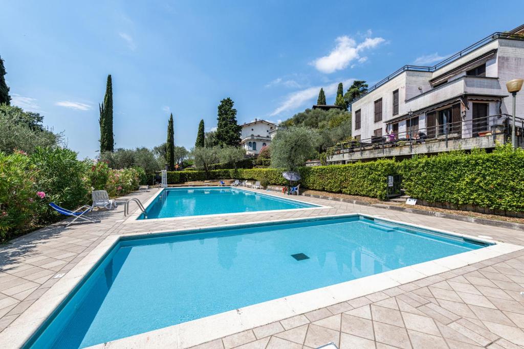 a large swimming pool in front of a house at Blue Moon duepunto0 in Gardone Riviera