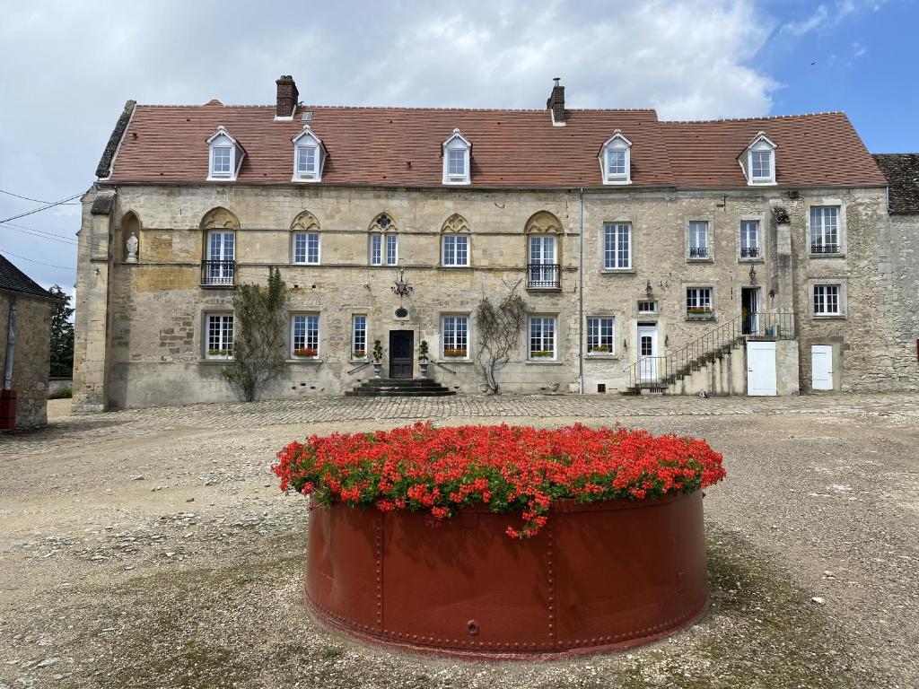 a large building with a pot of flowers in front of it at Maison Prieuré 