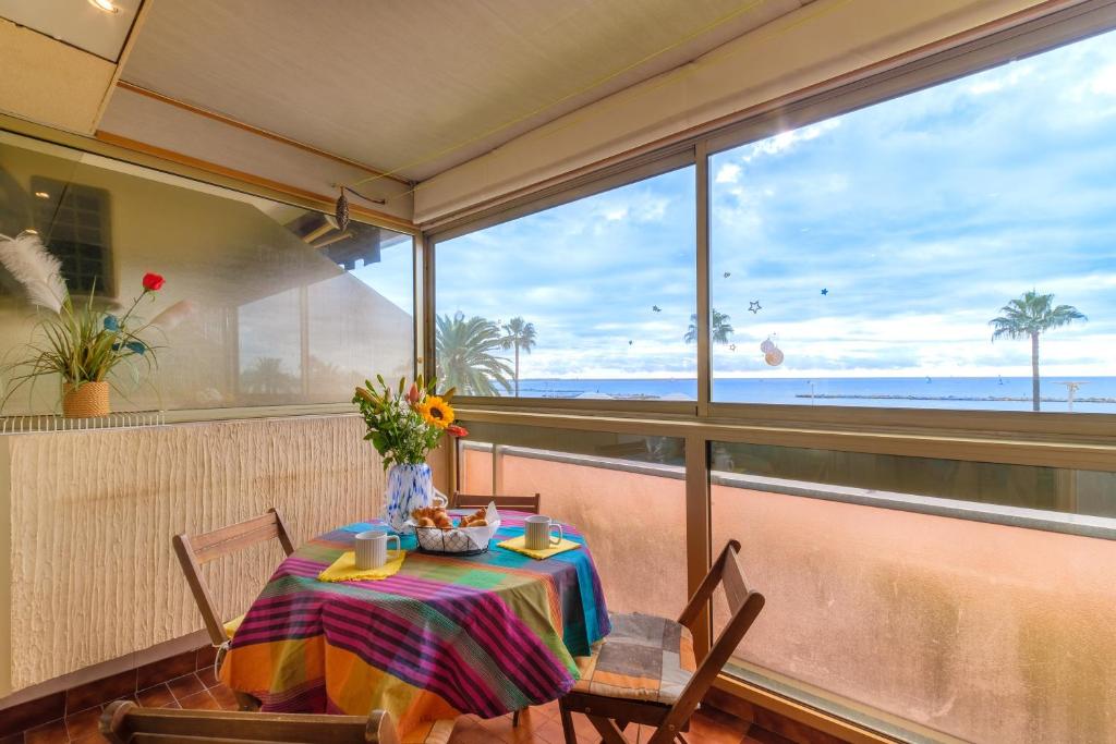 une salle à manger avec une table avec vue sur l'océan dans l'établissement Appartement Le Maeva, à Saint-Laurent-du-Var