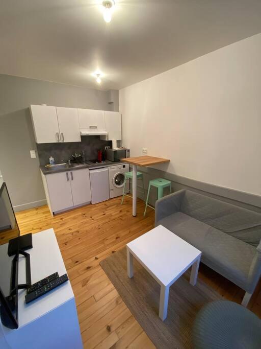 un salon avec un canapé et une cuisine dans l'établissement Coeur de Ville T2 Centre Jaude, à Clermont-Ferrand