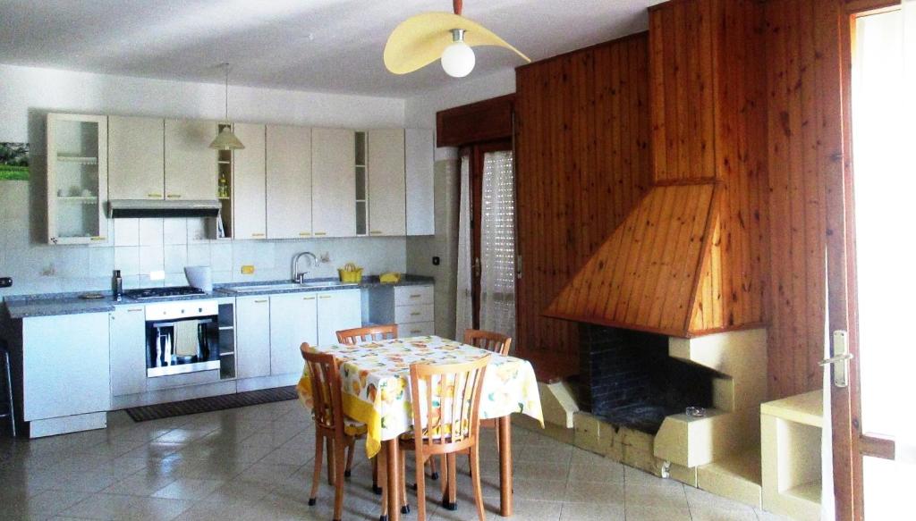 a kitchen with a table and a fireplace in it at Casa Velina in Castelnuovo Cilento