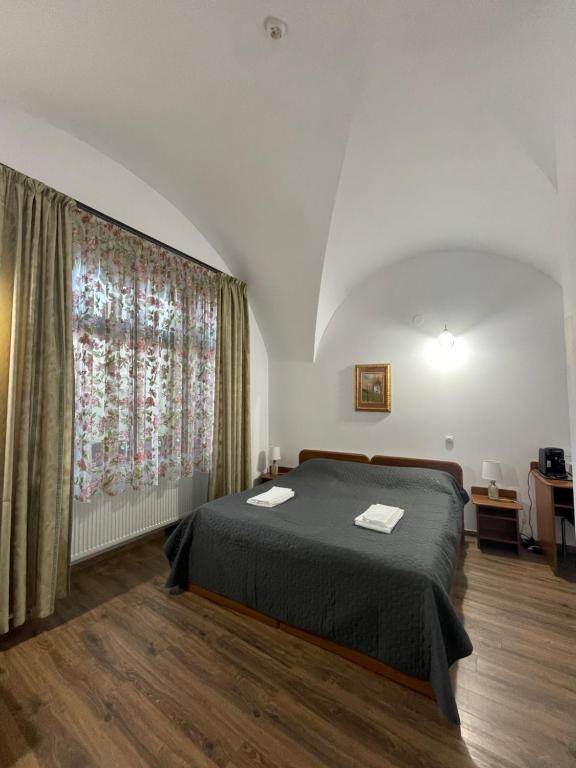 Un dormitorio con una cama y una ventana grande. en Casa Weidner, en Sibiu