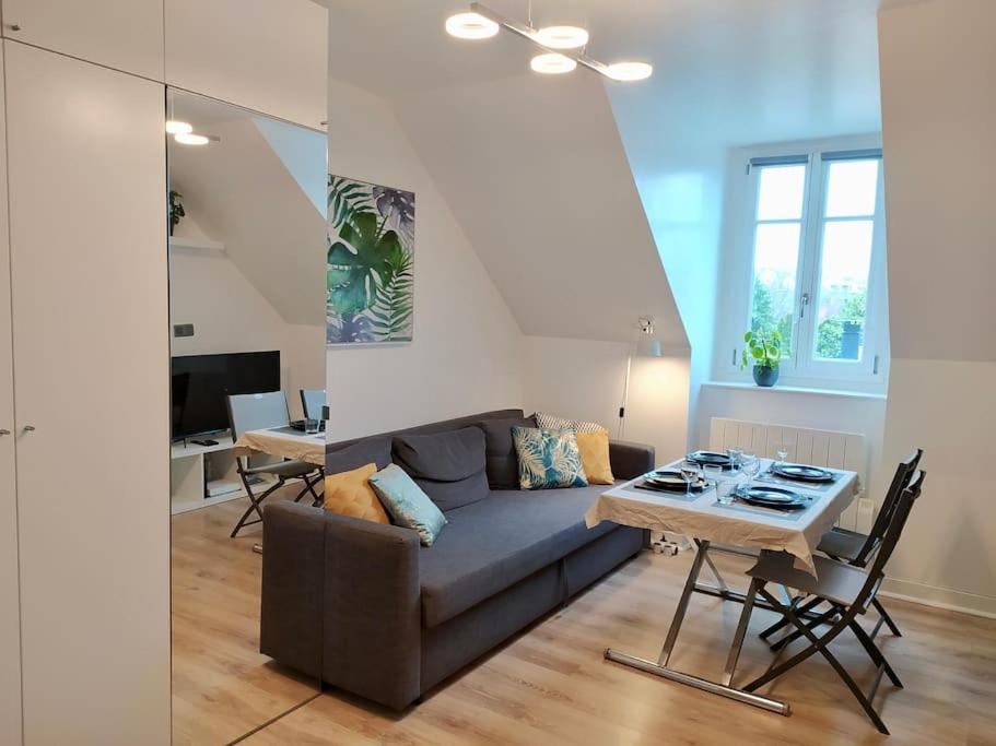 ein Wohnzimmer mit einem Sofa und einem Tisch in der Unterkunft ☆ T2 hypercentre ✢ plage à 400m ✢ tout équipé ☆ in Dinard