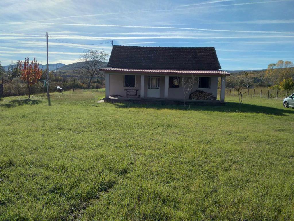 una pequeña casa blanca en un campo de hierba en Etno rural house,Bjelopavlići, Novo Selo, Danilovgrad en Danilovgrad