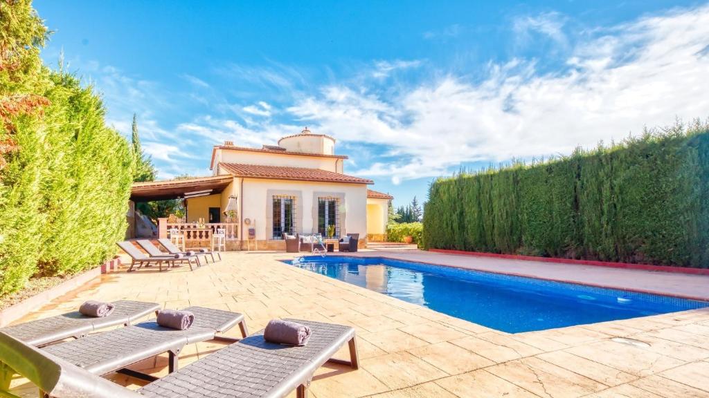 a backyard with a swimming pool and a house at Costacabana - Villa Roxy in Lloret de Mar