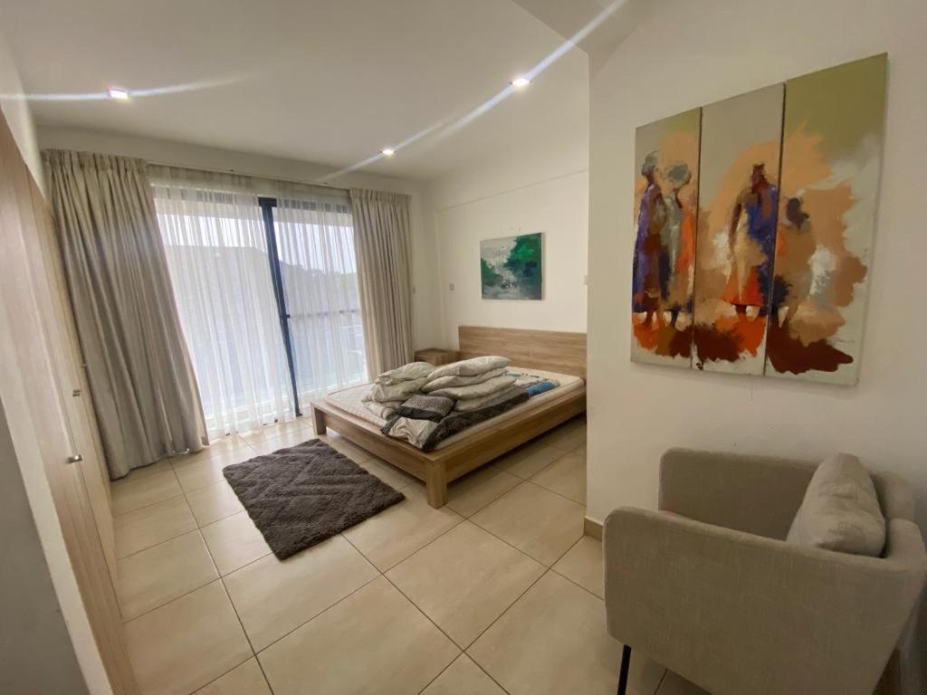 1 dormitorio con cama, sofá y ventana en Luxurious 2 Bedroom space Available en Accra