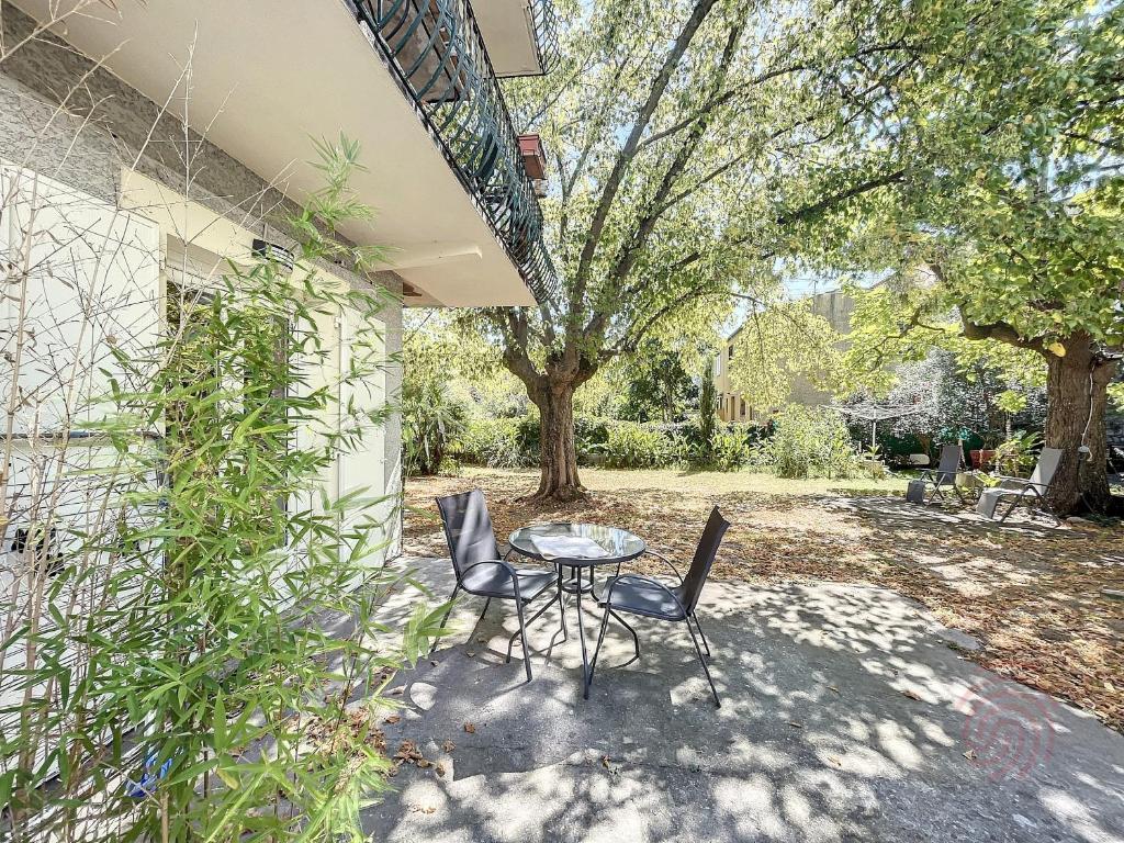 d'une terrasse avec une table et deux chaises. dans l'établissement Charmant studio avec terrasse Sud, proche thermes et centre - Lamalou-les-Bains - FR-1-451-190, à Lamalou-les-Bains