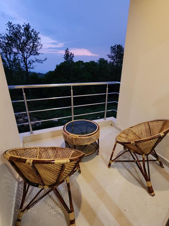 two chairs and a fire pit on a balcony at Coffee valley resort (CVR) in Yercaud