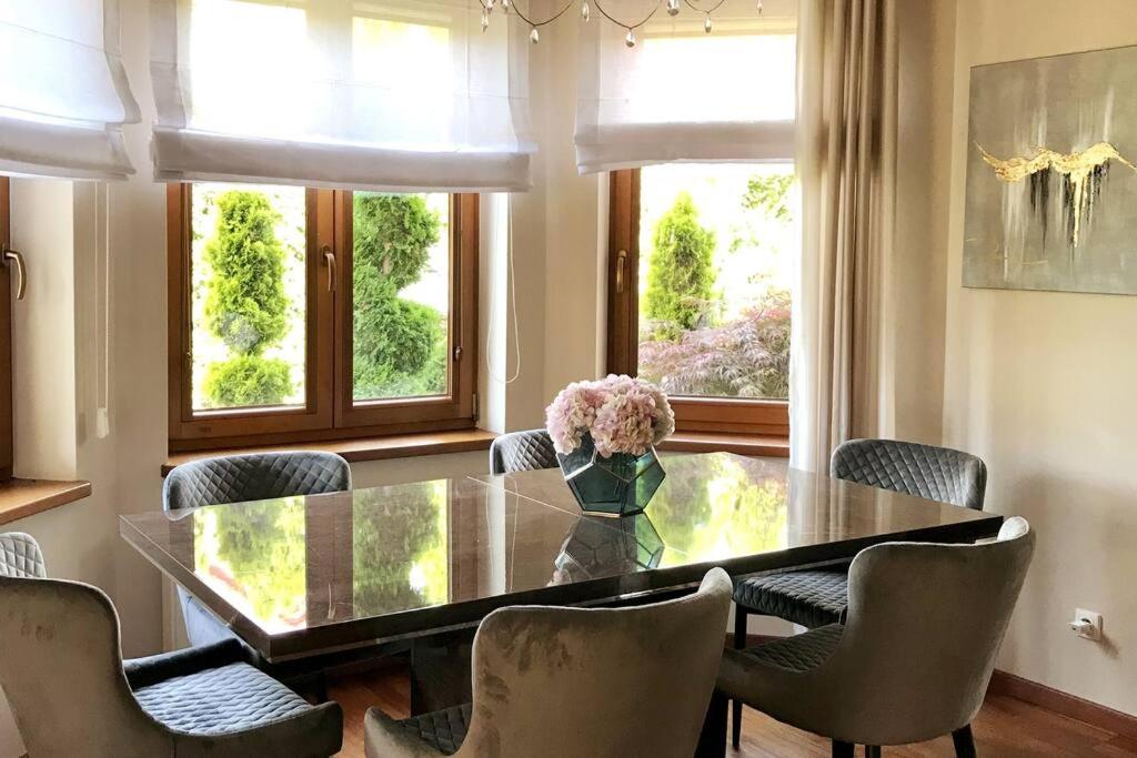 a dining room with a glass table and chairs at Family house in Wieliczka