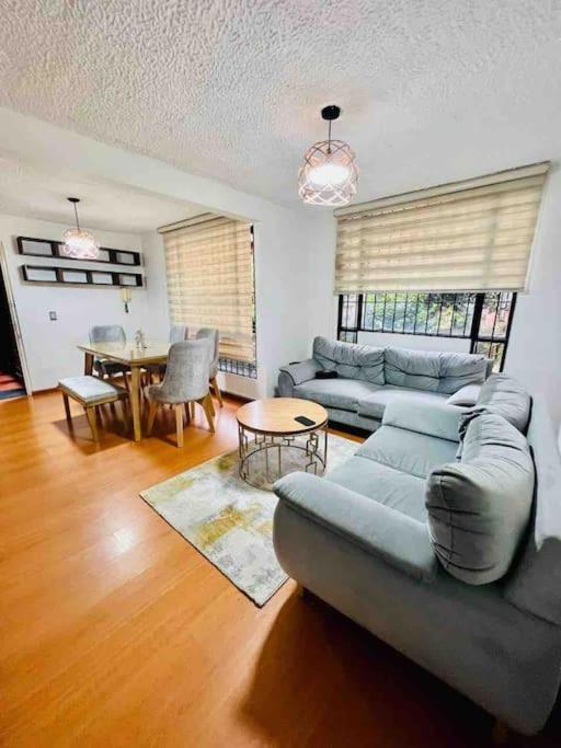 ein Wohnzimmer mit einem Sofa und einem Tisch in der Unterkunft “Hermoso y cómodo apartamento cerca al aeropuerto! in Bogotá