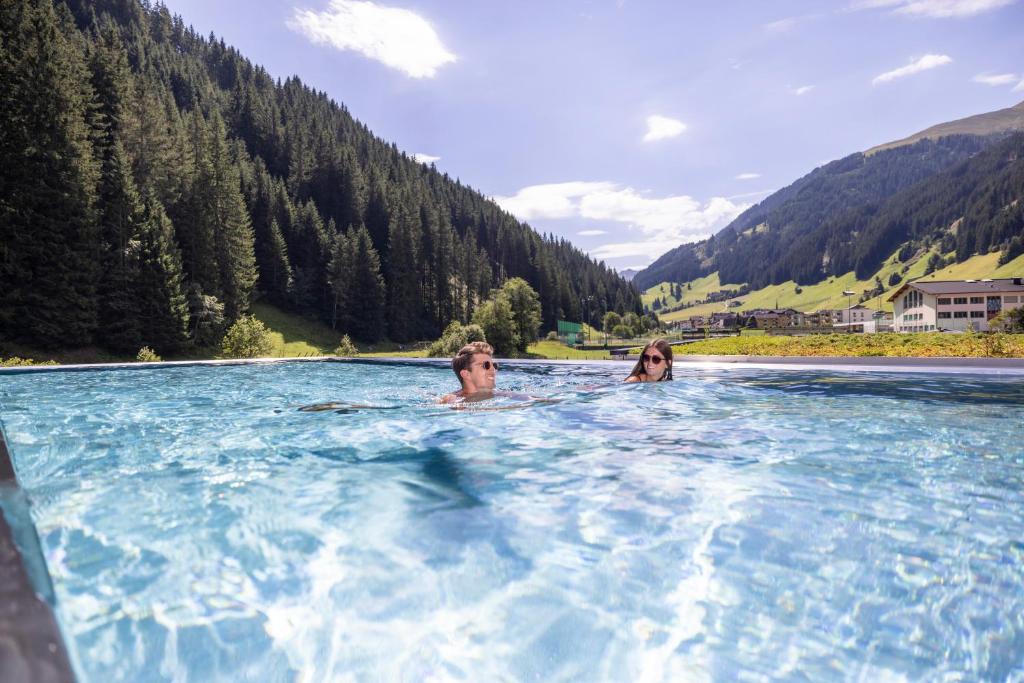 a man and a woman in a pool of water at Natur- & Wanderhotel Tuxertal in Tux