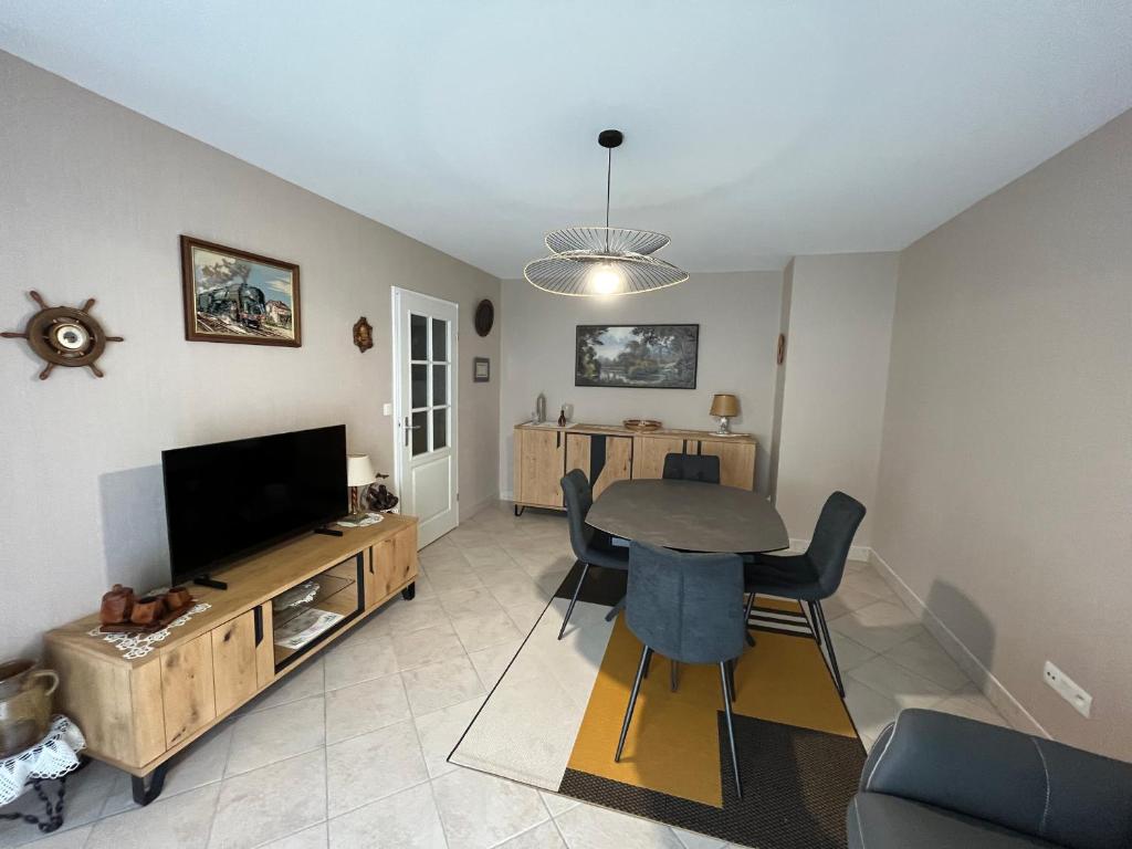 a living room with a table and a television at Appartement Les Sables-d'Olonne, 2 pièces, 2 personnes - FR-1-197-583 in Les Sables-d'Olonne