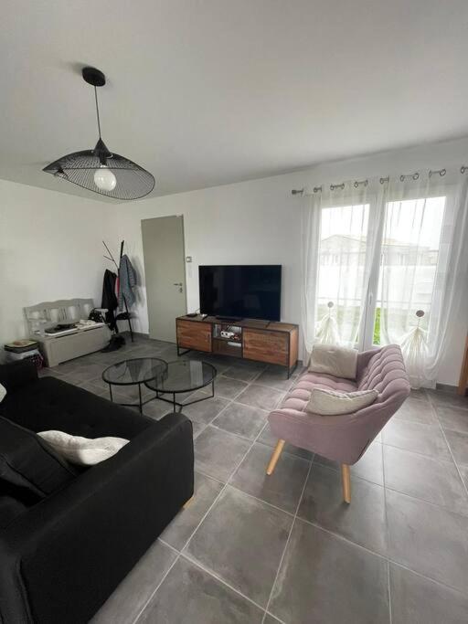 un salon avec deux canapés et une télévision dans l'établissement Maison Moderne à Saint-Denis, à Saint-Denis-dʼOléron