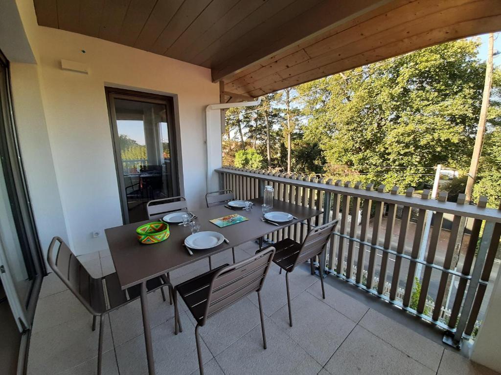 un balcon avec une table et des chaises sur un balcon dans l'établissement Charmant appartement neuf à Capbreton avec balcon, Wifi, et parking sécurisé pour 5 personnes - FR-1-239-1004, à Capbreton